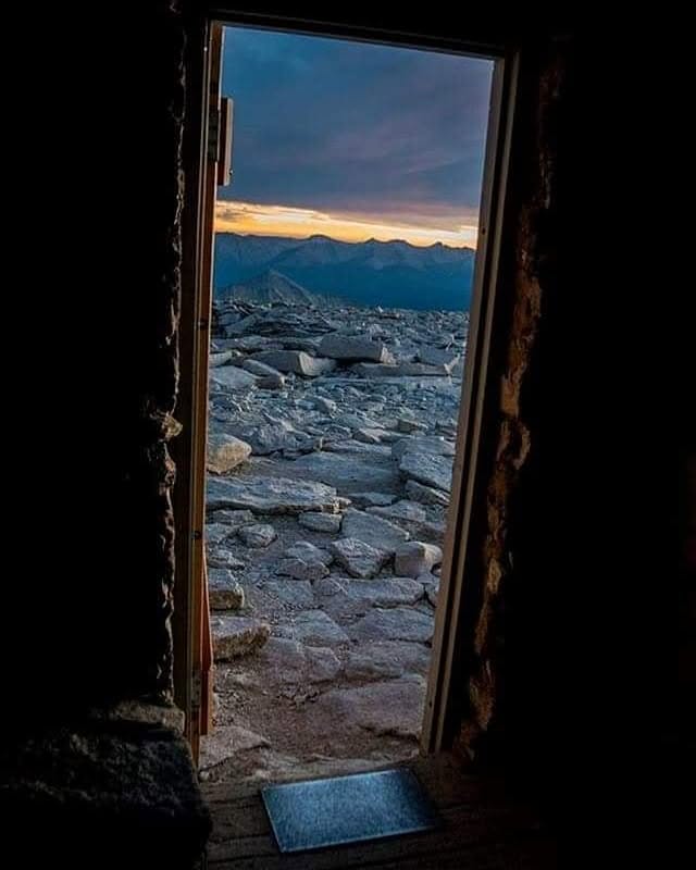 Sunset and high Sierra talus seen through a mountain shelter doorway