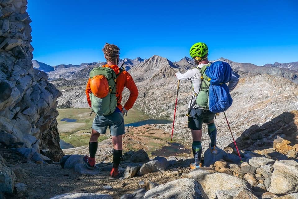 Two athletes look across the broad ridges surrounding the Merced Lake drainage