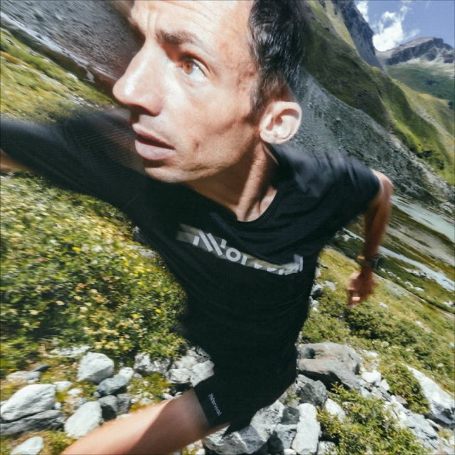 Kilian Jornet runs uphill through steep mountain terrain