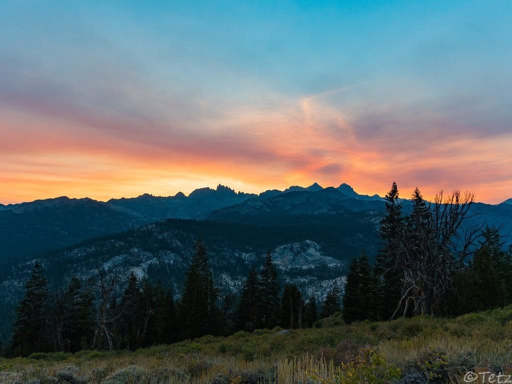 The jagged Minarets form a dark silhouette beneath a vivid pink and orange sunset