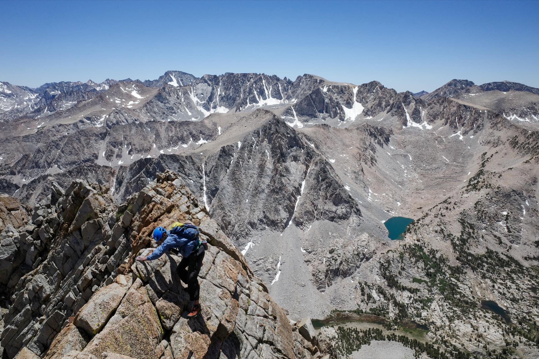 A climber traverses exposed granite on the Mount Emerson Waterfall Route above the North Lake basin