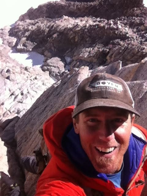 Ryan Boyer smiles for a selfie among pale alpine granite