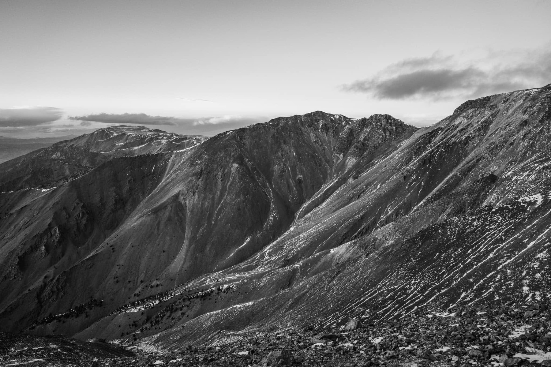A black-and-white view across snow-streaked steep ridges in the White Mountains