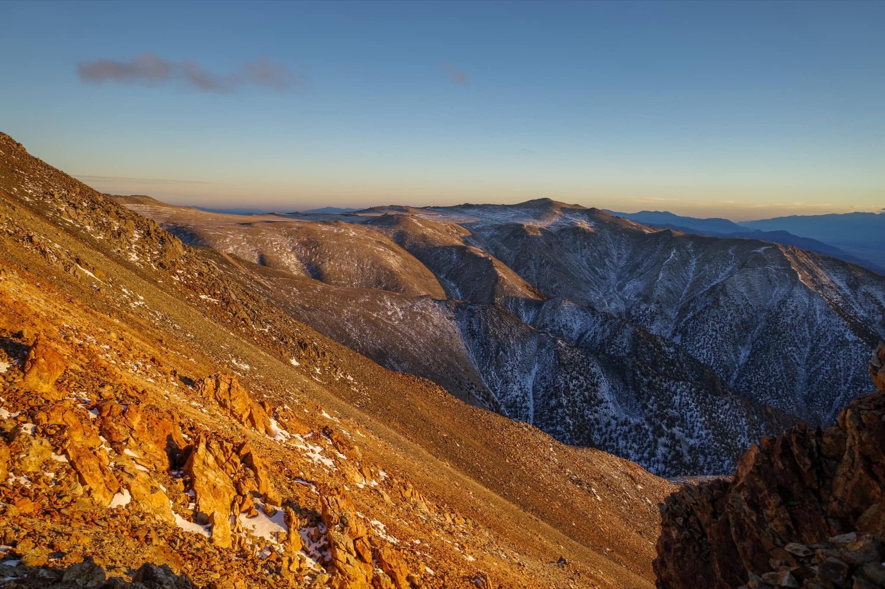 Golden evening light crosses the broad dry ridges of the White Mountains