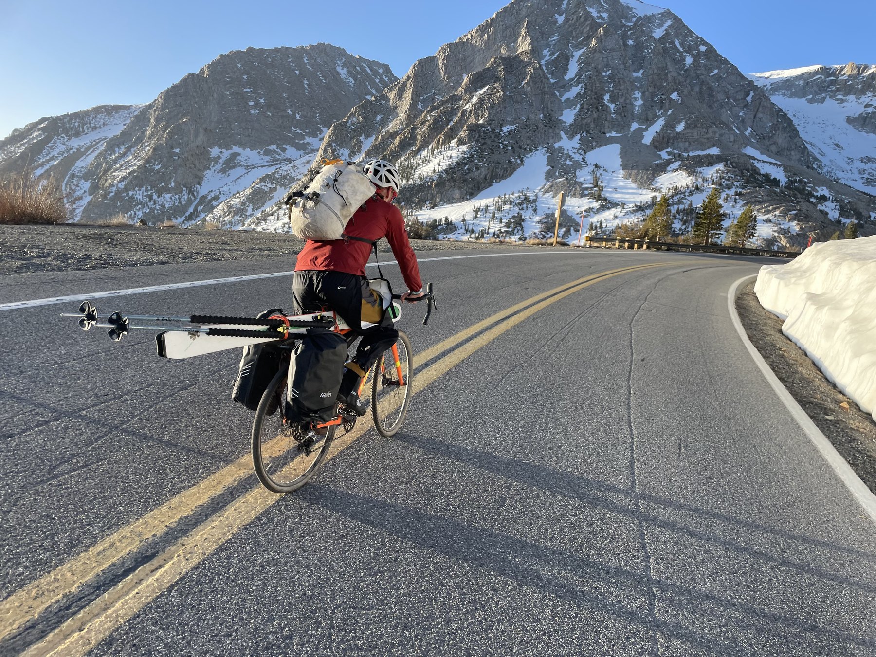 Leo Franchi rides a loaded bicycle carrying skis along Tioga Road during the 2022 Yosemite Winter Picnic