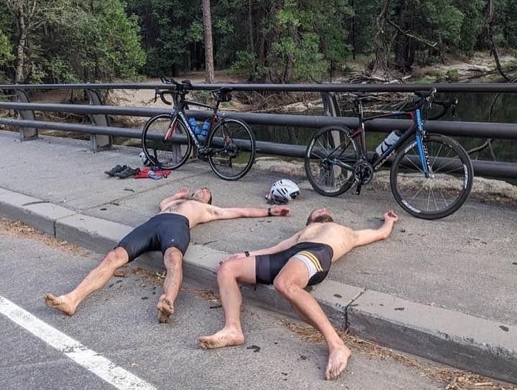 Ryan Tetz and Jason Hardrath lie beside their bicycles after finishing the 2020 Yosemite Picnic